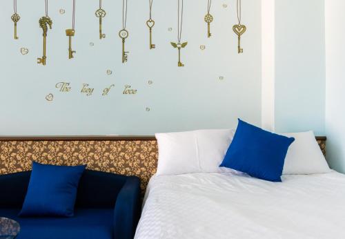 台東市的住宿－台東新東方藍，一间卧室配有一张带蓝色枕头和吊灯的床。