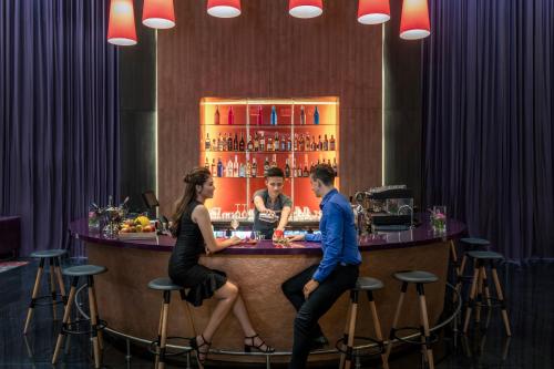 a man and a woman sitting at a bar at Mercure Hai Phong in Hai Phong