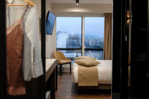 een hotelkamer met een bed en een groot raam bij B4B Athens 365 in Athene