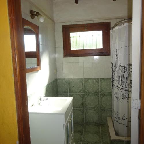 y baño con lavabo y ducha. en casa barrio golf en Tandil