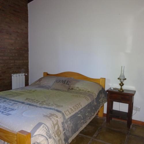 1 dormitorio con cama y mesita de noche con mesa en casa barrio golf en Tandil