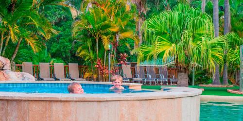 dos niños en una piscina en un complejo en The Palms At Avoca, en Avoca Beach