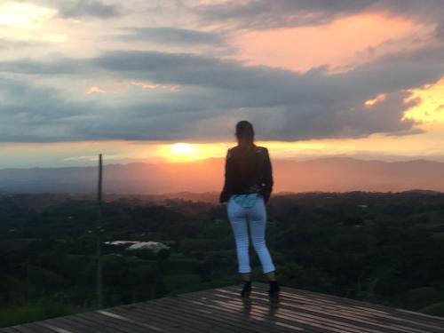 a woman standing on top of a tower looking at the sunset at Santa Elena de la Colina in Filandia