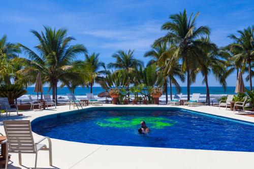 a woman is in the pool at a resort at The Resort at Majahua Palms in Troncones