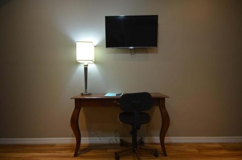 a desk with a lamp and a chair in a room at Suites del Sol in Tijuana
