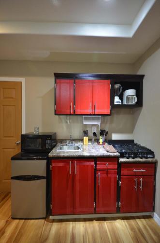 a kitchen with red cabinets and a sink at Suites del Sol in Tijuana