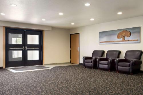 a waiting room with leather chairs and a door at Travelodge by Wyndham Bill WY Thunder Basin Ntl Grassland in Bill