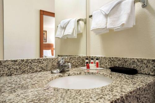 a bathroom counter with a sink and a mirror at Travelodge by Wyndham Bill WY Thunder Basin Ntl Grassland in Bill
