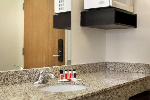 a bathroom counter with a sink and a mirror at Travelodge by Wyndham Yampa in Yampa