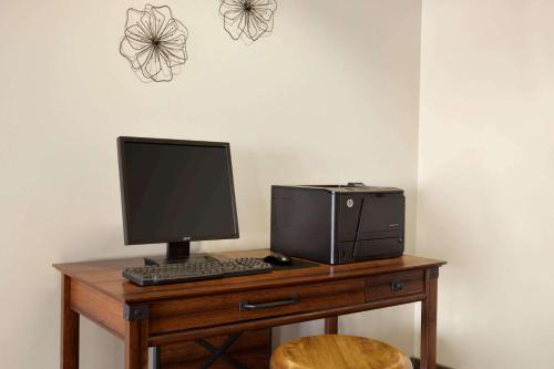 a desk with a computer and a printer on it at Baymont by Wyndham Wellington in Wellington