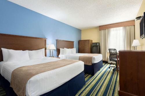 a hotel room with two beds and a desk at Days Inn by Wyndham Fargo in Fargo