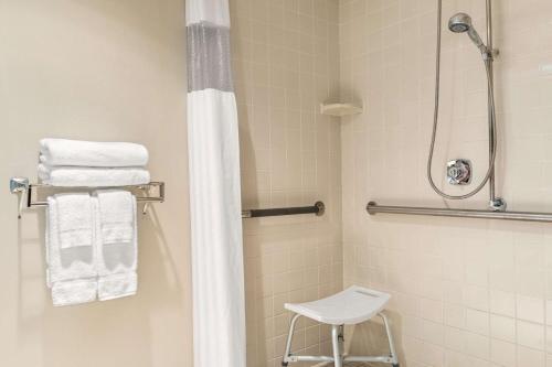 y baño con ducha, aseo y toallas. en Days Inn by Wyndham Fargo en Fargo