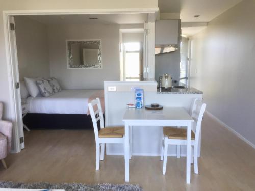 a small kitchen with a white table and chairs in a room at Oneroa Bay Villas in Oneroa