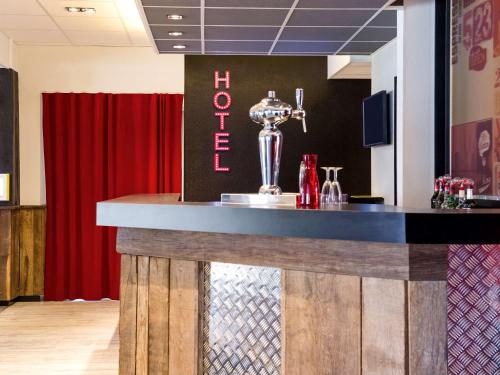 a bar in a restaurant with a red curtain at ibis Styles Chartres Métropole in Chartres