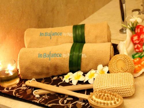 a table with towels and flowers and a candle at Novotel Bangka Hotel & Convention Center in Pangkalpinang