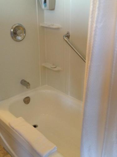 a white bathroom with a tub and a shower at Hopewell Rocks Motel & Country Inn in Hopewell Cape