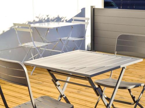 a picnic table and two chairs on a deck at ibis budget Pau Lescar in Lescar