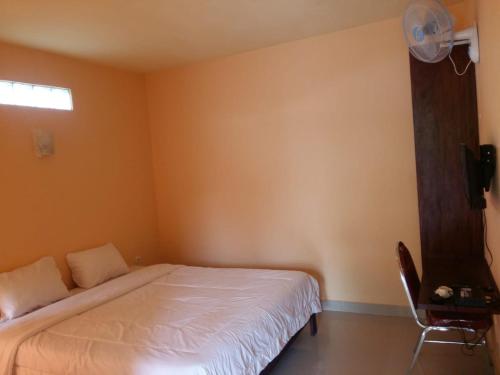 1 dormitorio con 1 cama y 1 silla en Antoneri Lodge, en Kelimutu