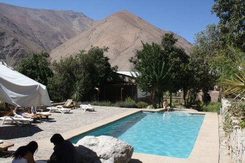 a swimming pool with a mountain in the background at Hotel El Milagro in Pisco Elqui