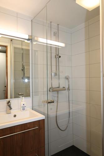 a bathroom with a shower and a sink at Varala Sports & Nature Hotel in Tampere