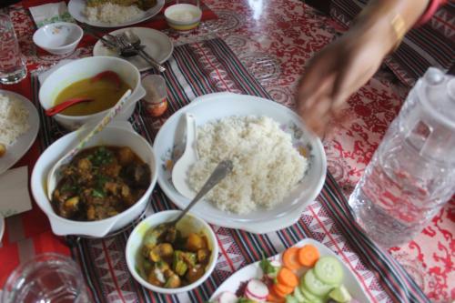 a table with rice and other dishes of food at Mansarover Home Stay in Kalimpong