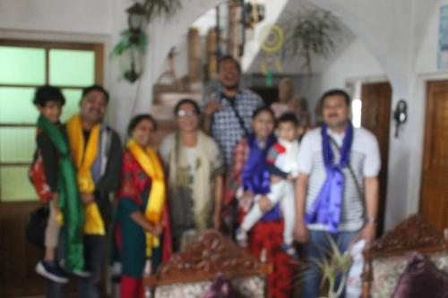 a family posing for a picture in a living room at Mansarover Home Stay in Kalimpong