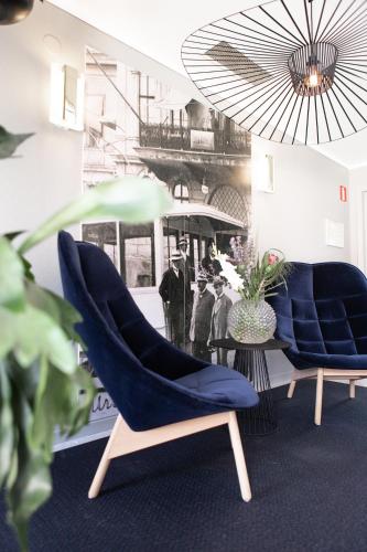 two blue chairs and a table in a room at Hotell Bogesund in Ulricehamn