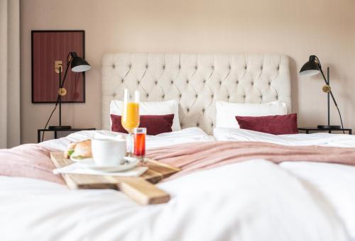 a bed with a tray of food and drinks on it at Hotell Bogesund in Ulricehamn