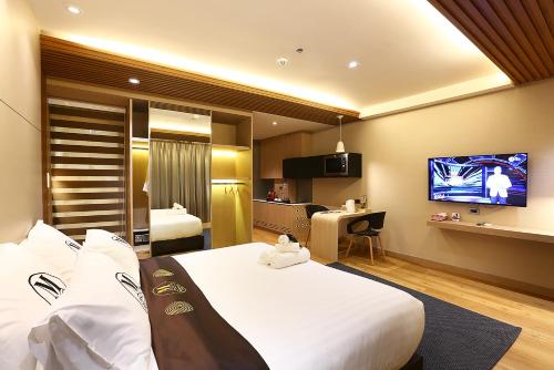 a hotel room with a large bed and a flat screen tv at Montana Hotel Songkhla in Songkhla