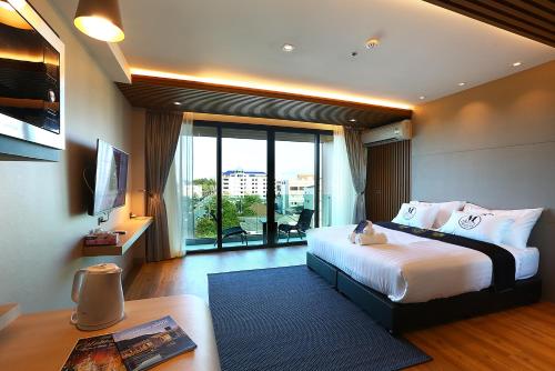 ソンクラーにあるMontana Hotel Songkhlaのベッドと大きな窓が備わるホテルルームです。