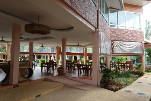 an open lobby with tables and chairs and windows at Chivatara Resort Bang Tao Beach Phuket - SHA in Bang Tao Beach