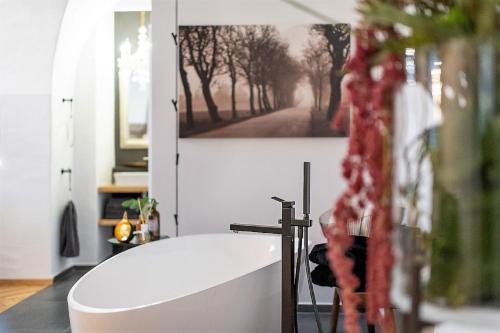 uma banheira na casa de banho com uma fotografia na parede em Passau42 em Passau