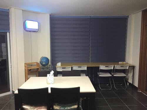 a conference room with a table and chairs and a television at Jeju Guesthouse in Jeju