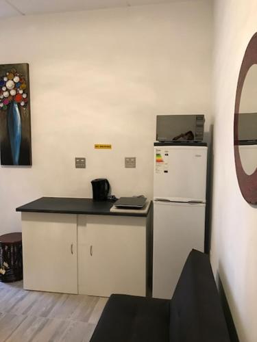 a kitchen with a white refrigerator and a counter at Modern rooms available close to the beach in Humewood in Port Elizabeth