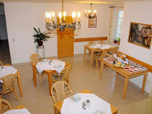 a dining room with tables and chairs and a chandelier at Privatzimmer Familie Schwarz in Vienna