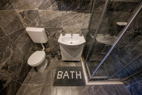 a bathroom with a toilet and a bath sign on the floor at Apartments Vukman in Trogir