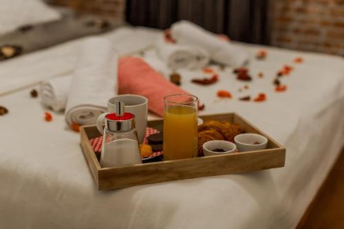 a tray of food and a glass of juice on a bed at Apartments Vukman in Trogir