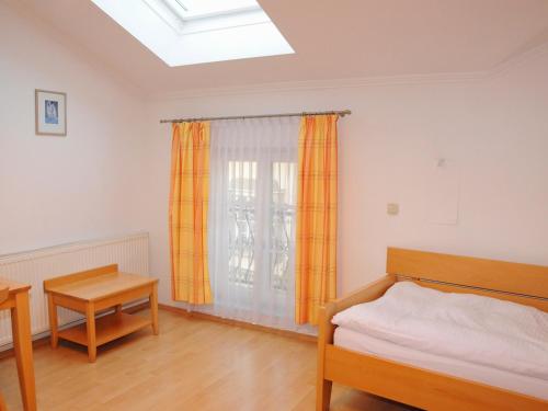 a bedroom with a bed and a table and a window at Privatzimmer Familie Schwarz in Vienna