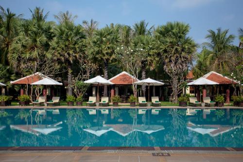 a pool at a resort with palm trees in the background at Royal Angkor Resort & Spa in Siem Reap