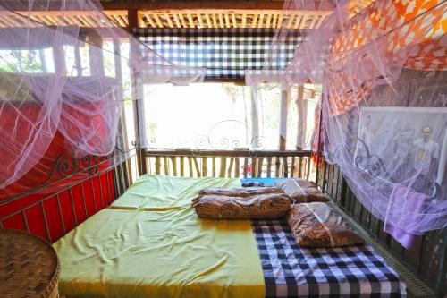 1 dormitorio con 1 cama en una habitación con cortinas en NewAlasKuliner & HomestayWatulumbung, en Yogyakarta