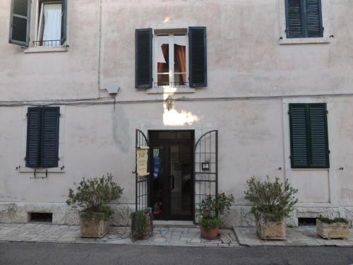 a white building with a door and a window at B&B Il Giardino Etrusco in Saturnia