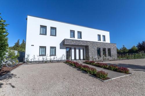 a large white building with a driveway at ManavaHotel in Herstal