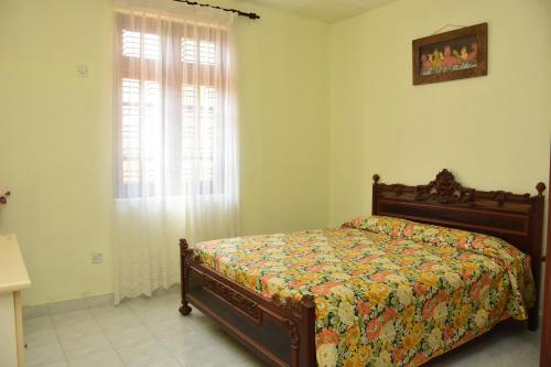 a bedroom with a bed and a window at Villa Roma - Negombo in Negombo