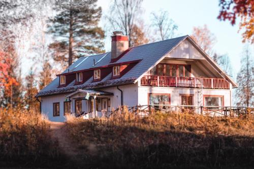 a large white house with a black roof at Vildmarks Lodge in Ytterhogdal