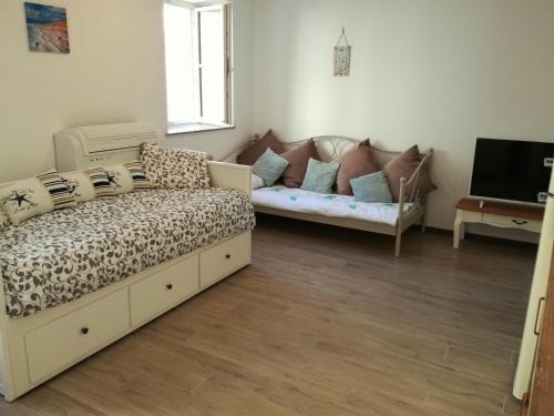 a living room with a couch and a tv at Apartment Lunaja in Piran