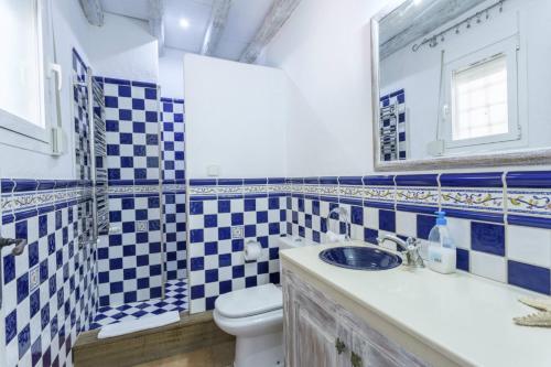 イビサ・タウンにあるVilla Savines is a luxury villa close to Ibiza Town and Playa Den Bossaの青と白のバスルーム(トイレ、シンク付)