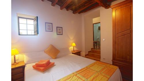 une chambre avec un grand lit blanc avec une fenêtre dans l'établissement Can Tunicu has amazing sea views and is located in a quiet area near to San Antonio, à Sant Antoni de Portmany