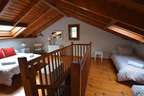 Cette chambre mansardée comprend un lit et un escalier. dans l'établissement Casa con encanto, jardín, vistas y piscina, à Estavar