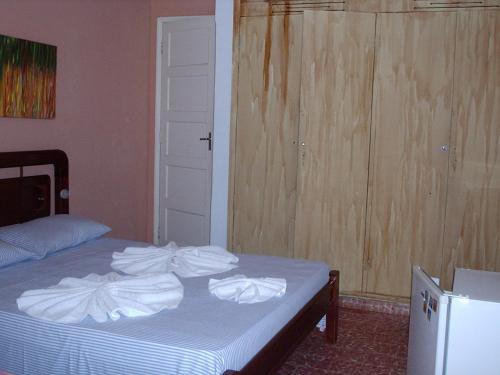 a bedroom with a bed with towels on it at Pousada da Lenna in Rio das Ostras