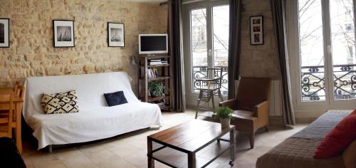 a living room with a white couch and a table at Appartement clair et lumineux au centre de Paris in Paris
